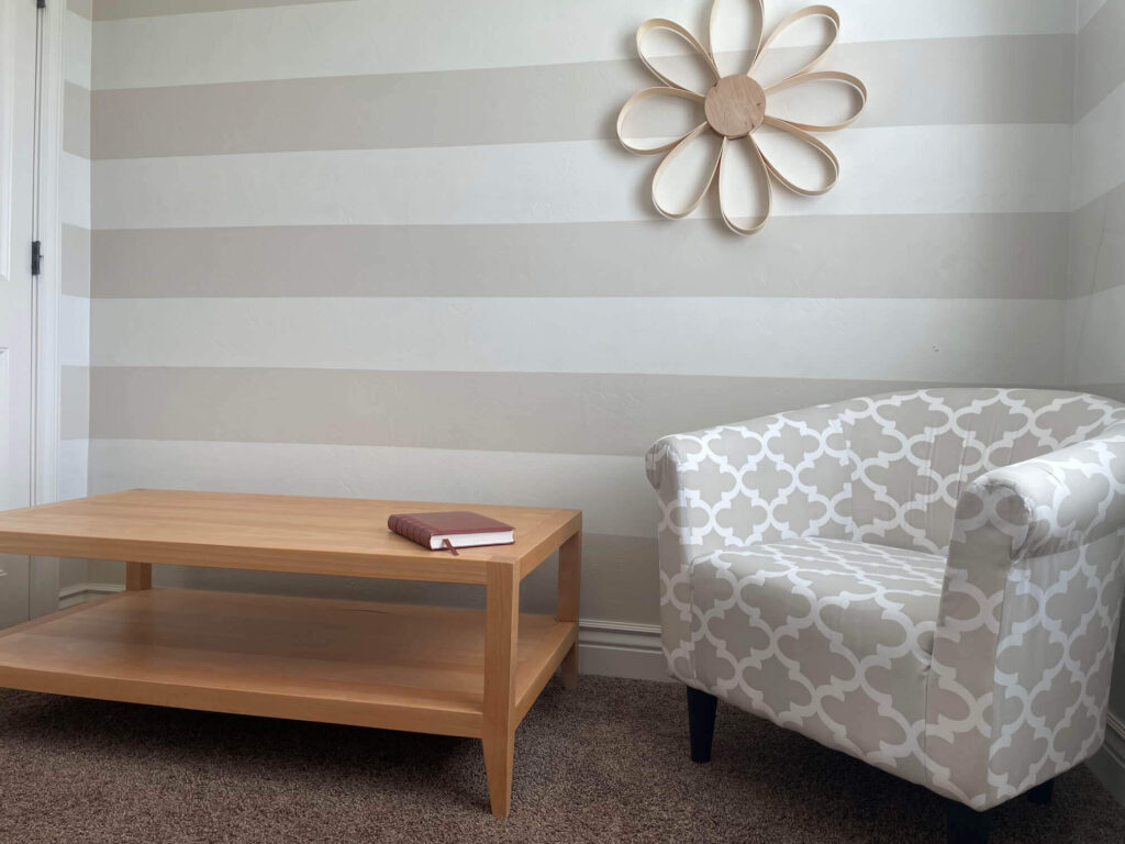 A custom longe table with a book on it and a sofa besides the table - Built by Fox in the Sawdust